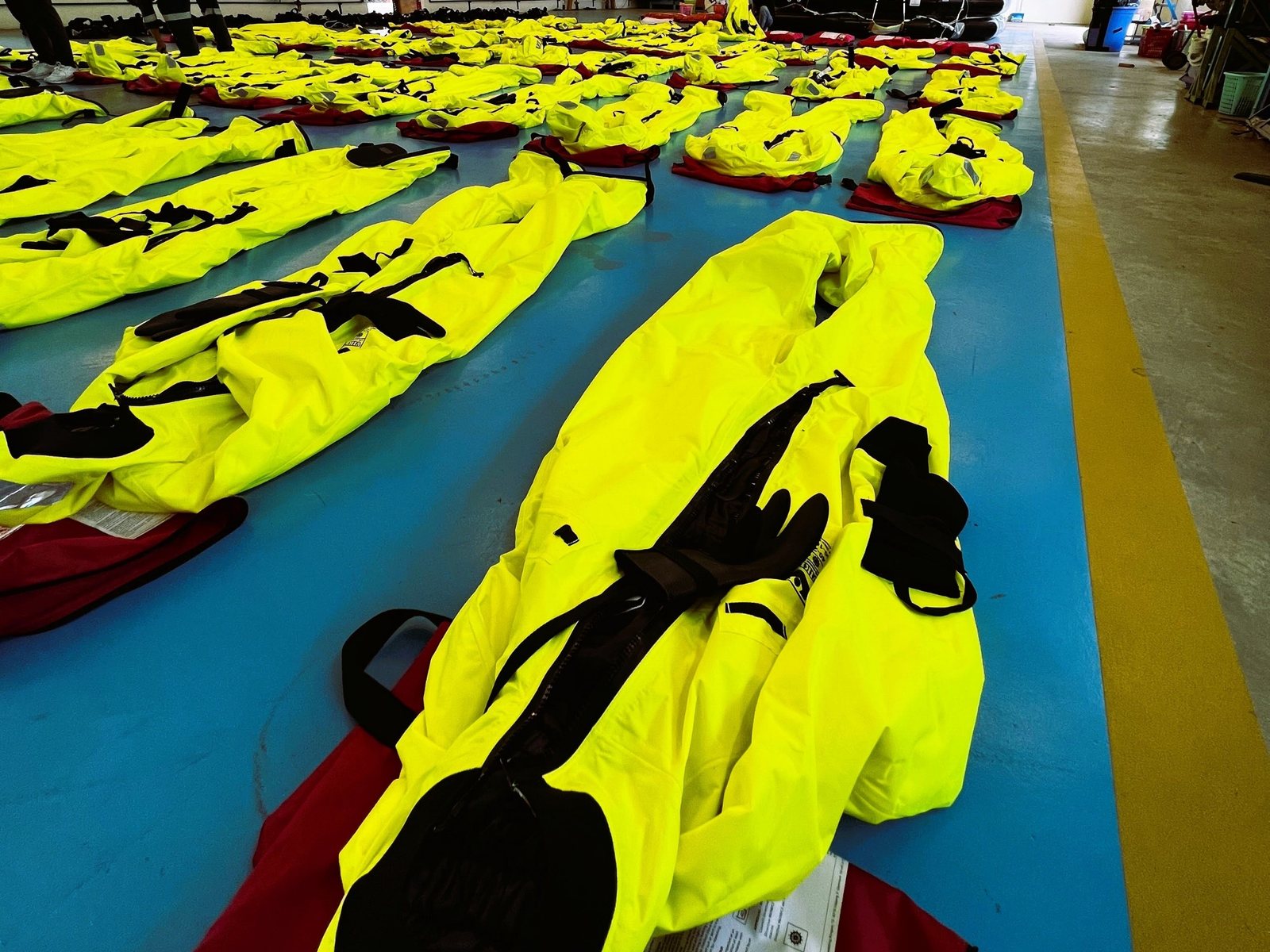 Immersion suits and lifejackets laid out for inspection at Mermaid