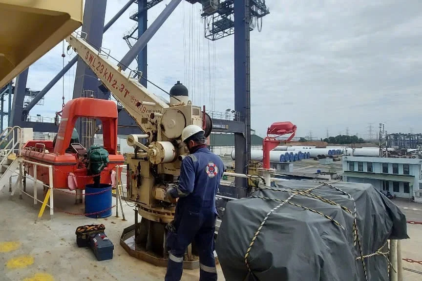 Mermaid technician load testing a rescue boat davit at the port
